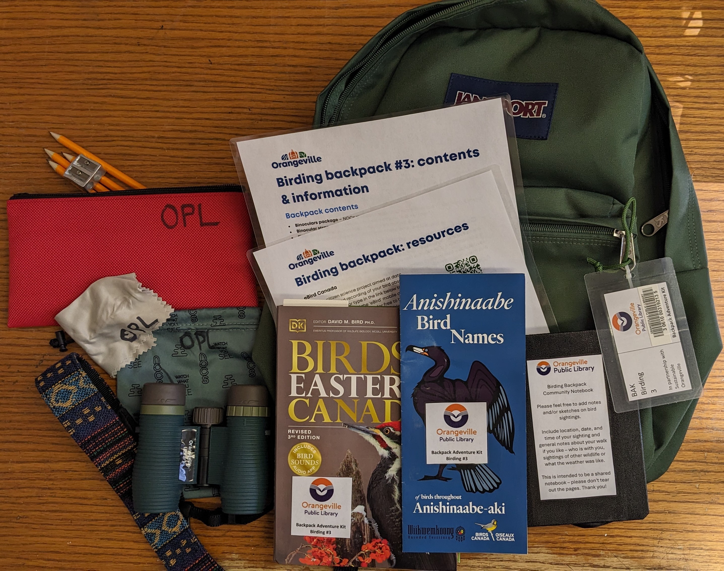 binoculars, books and pencils on a backpack