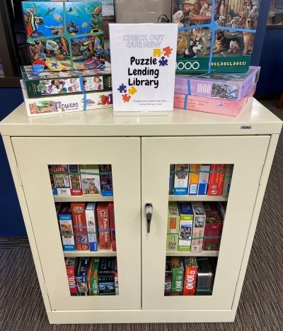 cabinet with glass doors filled with jigsaw puzzles